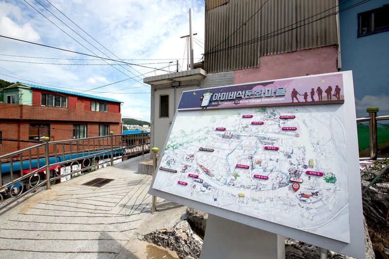 An information board for Ami Tombstone Cultural Village, with a hand-drawn map marking the tombstone spots around the village.